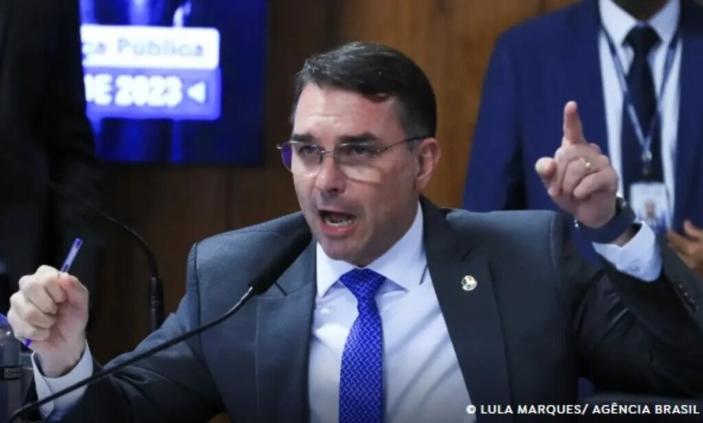 Homem em terno gesticula enquanto fala em uma audiência pública no TSE sobre investigação de Flávio Bolsonaro